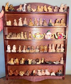 a wooden shelf filled with lots of figurines on top of it's sides