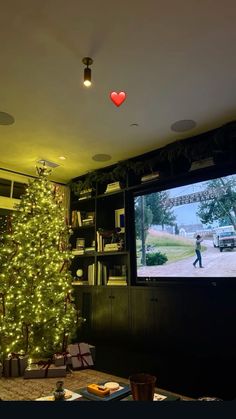 a living room with a christmas tree in the corner and a television on top of it