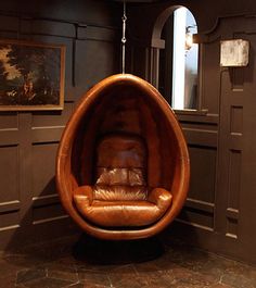 a brown leather chair hanging from the ceiling