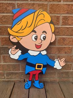 a wooden cutout of a cartoon character on a wood floor in front of a brick wall