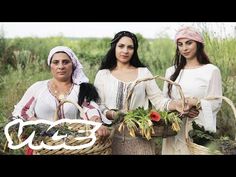 three women are standing in a field holding baskets