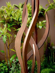 a metal sculpture in the middle of a garden