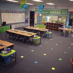 an empty classroom with desks, chairs and decorations on the walls in front of them