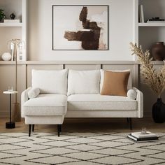 a living room with a white couch and some books on the shelf next to it