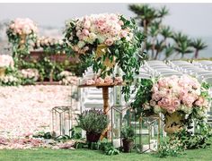 an outdoor ceremony setup with pink flowers and greenery