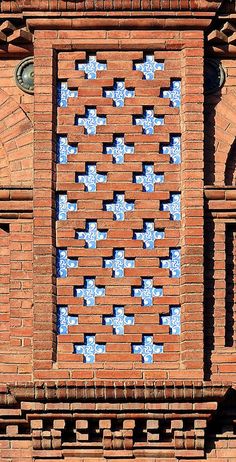 an old brick building with blue and white tiles on it