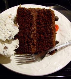 a piece of chocolate cake and ice cream on a white plate with a silver fork