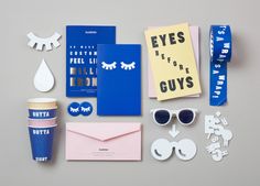 an assortment of items that include sunglasses, cards, paper and other things to make it look like they are on the table