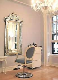 a salon chair sitting in front of a mirror on top of a hard wood floor