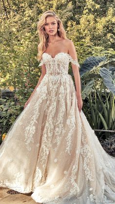 a woman in a wedding dress posing for the camera with her hand on her hip