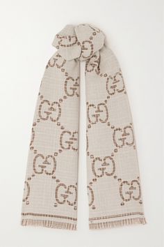 Gucci's scarf will suit a neutral winter wardrobe so well. Spun from soft wool-blend, this style is flecked with the subtlest metallic shimmer and woven with a maximal version of the label's iconic monogram. The ends are traced with touches of fringe. Luxury Gucci Scarves For Fall, Gucci Luxury Winter Scarves, Gucci Luxury Winter Scarf, Luxury Gucci Scarves For Winter, Luxury Gucci Scarf For Winter, Luxury Gucci Winter Scarves, Designer Gucci Scarves For Winter, Designer Gucci Winter Scarves, Gucci Designer Winter Scarves