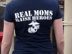 a woman wearing a t - shirt that says real moms raise hero's