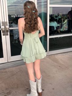 a woman standing in front of a glass door with her back turned to the camera