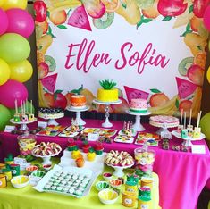 a table topped with lots of desserts and fruit on top of tables covered in balloons