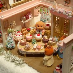 there is a doll house with cupcakes on the table and other toys in it