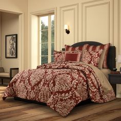 a bed with red and beige comforters in a room