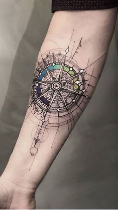 a man's arm with a compass tattoo on it