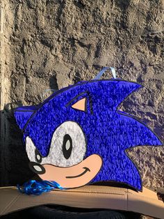 a blue sonic mask sitting on the back of a chair next to a stone wall