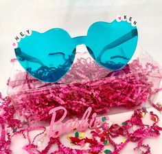 Hey Barbie! Let's Party! Get everyone ready for your summer party days with a pair of our super fun "Hey Ken" Heart Sunglasses! Little ones of all ages will have so much fun showing off their Barbie and Ken styles with these adorable sunglasses! -Package includes 1 pair. -Approximately 6in in length. -Material: plastic *Heart beads may vary in color. Fun Sunglasses For Valentine's Day Gift, Fun Sunglasses As Valentine's Day Gift, Playful Sunglasses For Valentine's Day Party, Playful Party Sunglasses For Valentine's Day, Playful Valentine's Day Party Sunglasses, Playful Blue Sunglasses For Party, Playful Blue Party Sunglasses, Trendy Blue Sunglasses For Gift, Trendy Blue Sunglasses As Gift