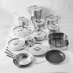 an assortment of stainless steel pots and pans on a marble countertop in black and white