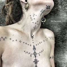 a woman with tattoos on her chest laying down