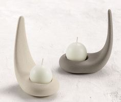 two candles sitting on top of each other in the shape of a crescent and an egg