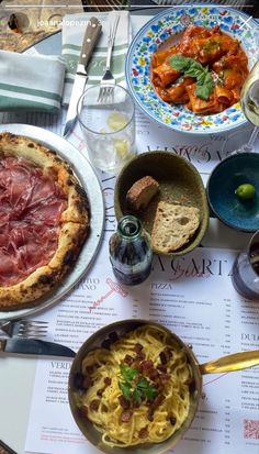 a table topped with different types of food next to wine glasses and utensils