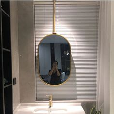 a woman taking a selfie in front of a bathroom mirror with the lights on