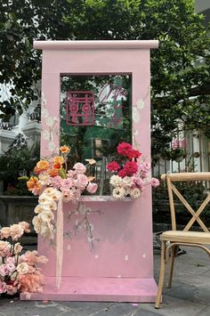 a pink stand with flowers in front of it