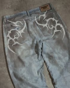 a pair of blue jeans with white designs on them