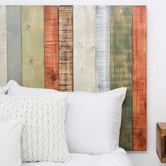 a bed with white pillows and wooden headboard made out of old wood planks