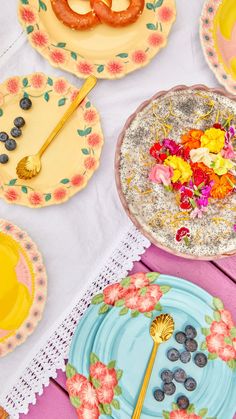 three plates with flowers and blueberries on them