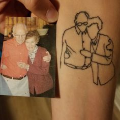 an old man and woman tattooing on their arm with the image of them hugging each other