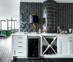 a kitchen with white cabinets and black tile backsplashing on the back wall