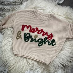 a pale beige personalised oversized sweater, hand embroidered 'Merry & Bright' in red, gold glitter and dark green.  The wool colour examples for the embroidery are as shown, however due to monitor/screen lighting, the colours might differ slightly.  This item is not refundable or exchangeable as each item is made to order. Please ensure that you wash on a low heat and delicate wash/ hand wash and do not tumble dry. Embroidery Sweater Diy, Embroidered Baby Clothes, Jumper Ideas, Diy Christmas Sweater, Embroidery Sweater, Baby Christmas Outfit, Embroidery Monogram, Embroidery On Clothes, Wool Crafts