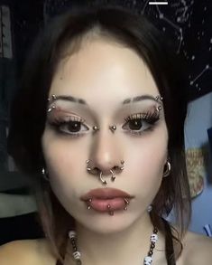 a woman with piercings on her face and nose