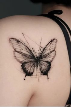 a black and white butterfly tattoo on the back of a woman's upper arm