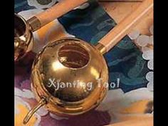 an old brass ball and two wooden spoons sitting on top of a colorful cloth