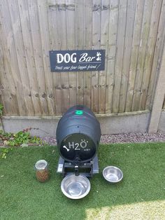 the dog bowl is next to two bowls on the grass in front of a fence