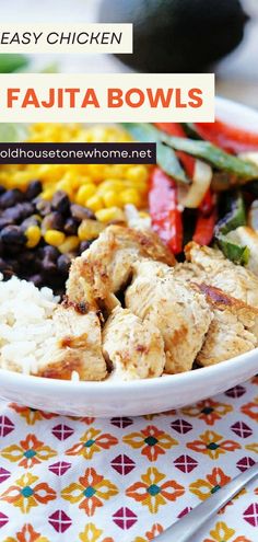 a white bowl filled with chicken, rice and beans on top of a colorful table cloth