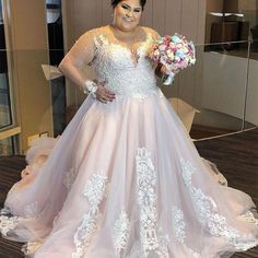 a woman standing in front of a mirror wearing a wedding dress