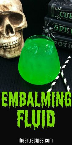 a green liquid in a glass next to a skull and some books with the words embalming fluid on it