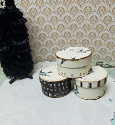 there are three cakes on the table with black and white decorations around them, one is decorated like a woman's head