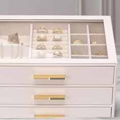 a white dresser with jewelry in it