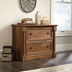 a wooden dresser with a clock on the wall