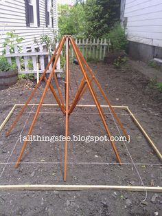 a wooden frame is in the dirt near a house