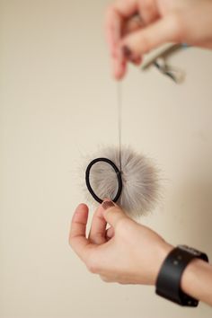 a woman is holding a dandelion in her hand while another person holds it