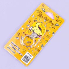 an image of a yellow keychain with cartoon characters on the front and back