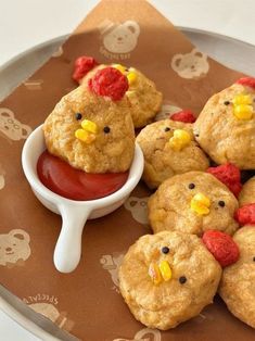 some cookies are sitting on a plate with ketchup and chicken heads in the middle