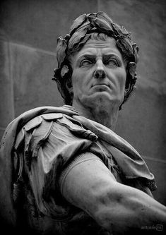 a black and white photo of a statue of a man with his hands on his hips